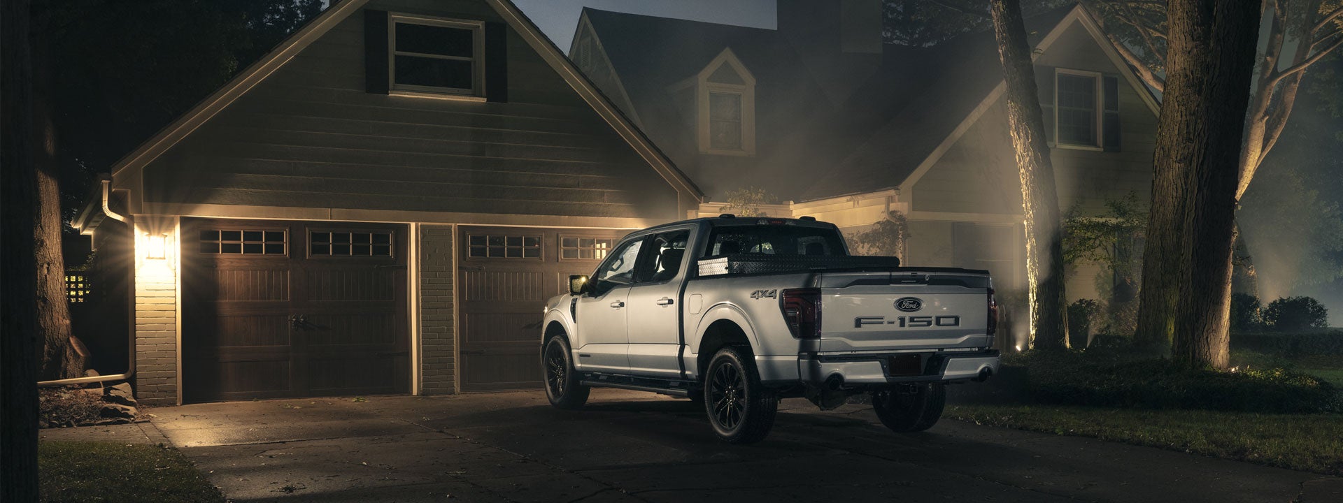 Truck parked in a driveway at night with security lighting on